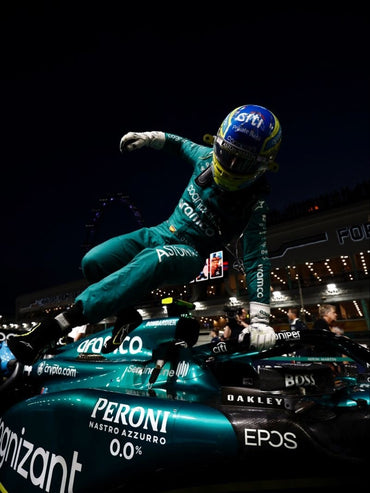 Aston Martin Formula 1 driver celebrating on top of the F1 race car after a Grand Prix