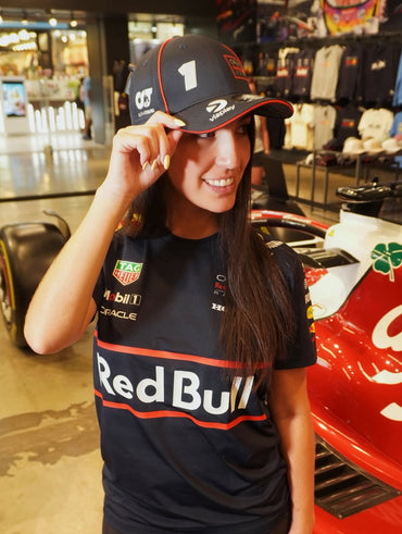 Woman wearing Red Bull Racing Formula 1 team shirt and cap inside an F1 merchandise store
