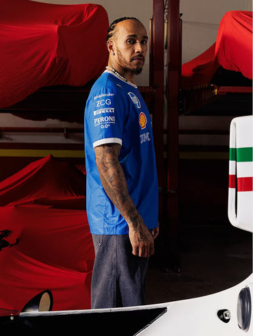 Formula 1 driver wearing Ferrari team shirt inside a racing garage